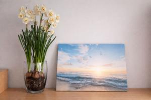 a vase with flowers sitting on a table next to a painting at Apartamenti dzīvoklis Ogre. in Ogre +4 photos