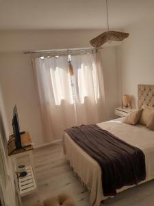 a bedroom with a bed and a tv and a window at Departamento in Mar del Plata