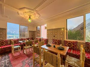 a restaurant with tables and chairs and large windows at Targa Imoula Luxe in Imlil