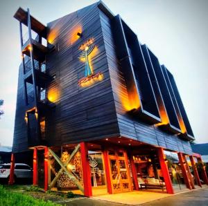 a black building with red doors and windows at Hotel Rangi Pucon in Pucón