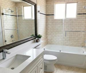 a bathroom with a tub and a toilet and a sink at Richmond 2-Bedroom Luxry Suite in Richmond