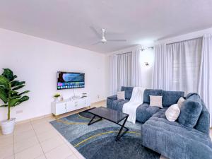 a living room with a blue couch and a tv at Diani hideouts in Kwale