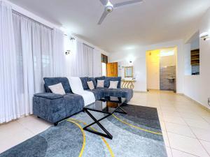 a living room with a blue couch and a chair at Diani hideouts in Kwale
