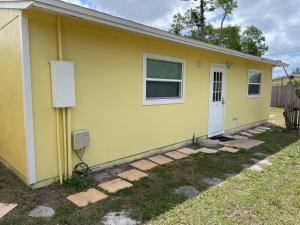a yellow house with a window and a door at Dolphin Cove in Sarasota