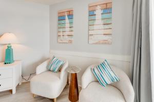 a living room with two chairs and a table at NEW Baywatch Remodled with Direct Oceanfront Views in Myrtle Beach +69 photos