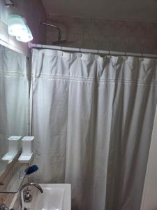 a bathroom with a shower curtain and a sink at Olivos Calm Stay in Olivos