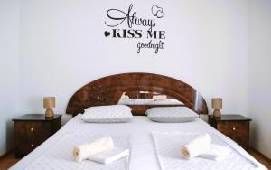 a bedroom with a bed with a sign that reads always kiss me comfortable at Apartmani Marijana in Bol