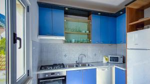 a kitchen with blue cabinets and a sink at Apartmani Marijana in Bol