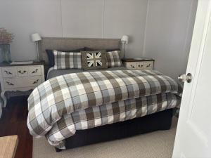 a bedroom with a bed with a blanket and pillows at Cambridge Cottage in Cambridge