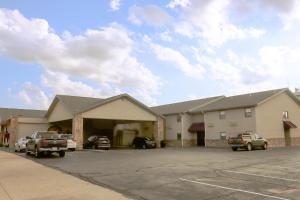 a building with cars parked in a parking lot at Apple Tree Inn in Independence