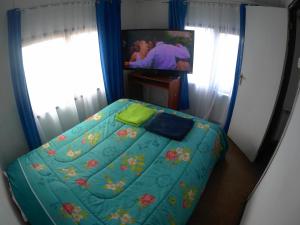 1 dormitorio con 1 cama y TV en Casita Independiente en Punta Arenas