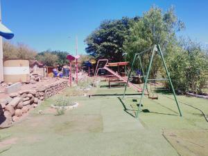 a playground with a swing set in a yard at Cabañas rústico in San Pedro de Atacama