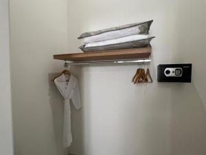 a shelf with a white shirt and a clock on a wall at El Encanto Inn & Suites in San José del Cabo