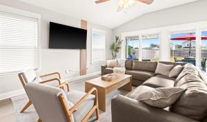 a living room with a couch and a tv at New Home with Fenced Yard Large Deck & Fire Pit in Navarre