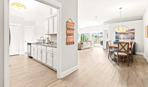 a kitchen and dining room with white cabinets and a table at New Home with Fenced Yard Large Deck & Fire Pit in Navarre
