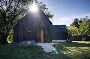 a black house with the sun shining on it at Watan A&D in Buna