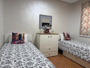 a bedroom with two beds and a mirror at Mirador Capo Negro in Cabo Negro