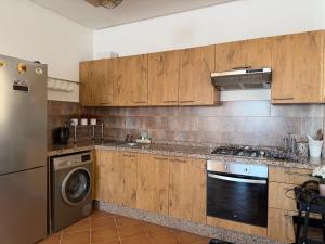 a kitchen with wooden cabinets and a washer and dryer at Mirador Capo Negro in Cabo Negro