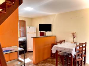 a small kitchen with a table and a refrigerator at Chalés Rio Soberbo in Caldas +10 photos