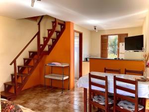 a kitchen and dining room with a table and a staircase at Chalés Rio Soberbo in Caldas