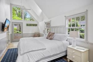 a white bedroom with a bed and two windows at The Songbird by Juniper Holiday + Home in New Buffalo