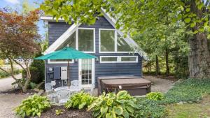 a blue tiny house with a picnic table and an umbrella at The Songbird by Juniper Holiday + Home in New Buffalo