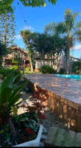 a backyard with a swimming pool and trees and a house at Pousada Laranjal em Pelotas in Pelotas