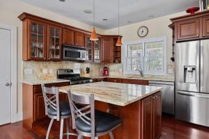 a kitchen with wooden cabinets and a marble counter top at Pete's Place by Juniper Holiday + Home in Sawyer