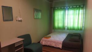 a bedroom with a bed and a desk and a window at Marco Polo Guest House in Kuching