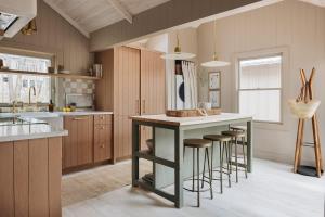 a kitchen with a island with bar stools at Townie 2 - The Sage by Juniper Holiday + Home Unit in Union Pier