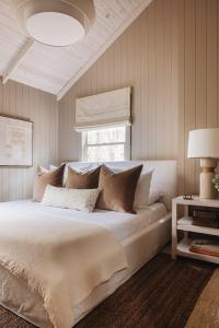 a bedroom with a large white bed with pillows at Townie 2 - The Sage by Juniper Holiday + Home Unit in Union Pier