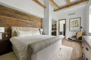 a bedroom with a large bed with a wooden wall at Black Door Bungalow by Juniper Holiday + Home in Lakeside