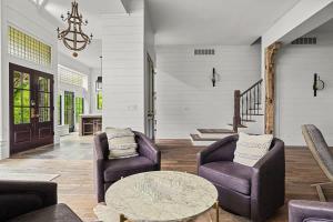 a living room with two chairs and a table at Black Door Bungalow by Juniper Holiday + Home in Lakeside +63 photos