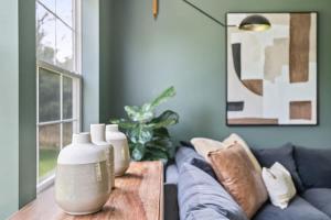 a living room with a couch and a table with vases at The Birdcage by Juniper Holiday + Home in Douglas