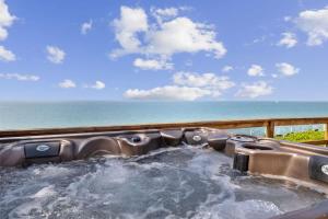 a hot tub with the ocean in the background at Lake Michigan Getaway by Juniper Holiday + Home in New Buffalo
