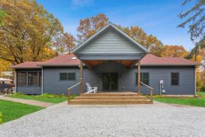 a gray house with a porch and stairs at The Dakota by Juniper Holiday + Home in Union Pier