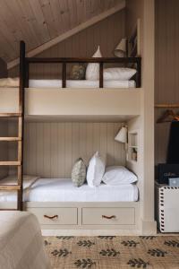 a bedroom with two bunk beds with white pillows at Townie 3 - The Moss by Juniper Holiday + Home in Union Pier