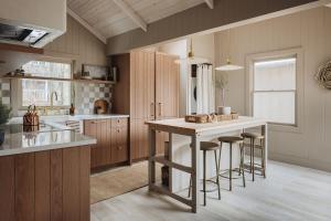 a kitchen with a large island with bar stools at Townie 3 - The Moss by Juniper Holiday + Home in Union Pier