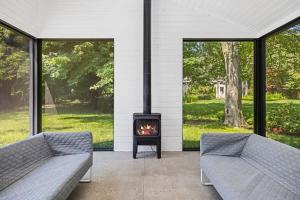 a living room with two couches and a fireplace at Owlwood by Juniper Holiday + Home in Harbert