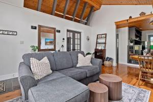 a living room with a gray couch and a table at Meadow Pines by Juniper Holiday + Home in Michigan City +34 photos