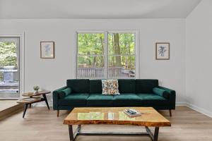 a living room with a green couch and a coffee table at The High Life by Juniper Holiday + Home in New Buffalo