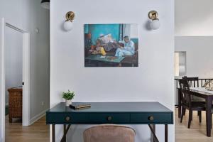 a desk in a living room with a painting on the wall at The High Life by Juniper Holiday + Home in New Buffalo