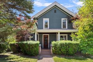 a gray house with a front door and bushes at The Fourth Oak by Juniper Holiday + Home in Three Oaks