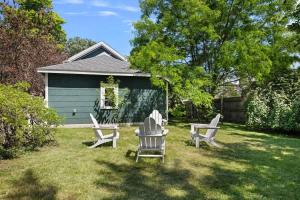 a yard with two chairs and a house at The Fourth Oak by Juniper Holiday + Home in Three Oaks