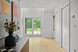 a hallway with a vase of flowers on a table at Gray Haven by Juniper Holiday + Home in Union Pier