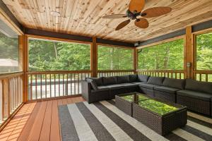 a screened in porch with a couch and a ceiling fan at Gray Haven by Juniper Holiday + Home in Union Pier