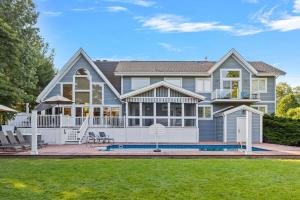 a large house with a swimming pool in the yard at Main Destination by Juniper Holiday + Home in Grand Beach