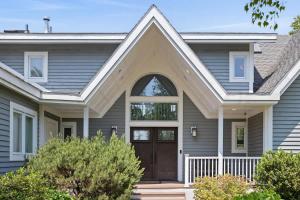 a gray house with a brown door at Main Destination by Juniper Holiday + Home in Grand Beach +43 photos