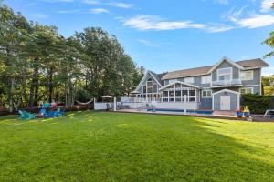 a house with a large yard with a large lawn at Main Destination by Juniper Holiday + Home in Grand Beach