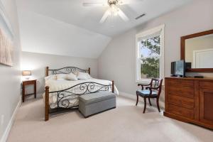 a bedroom with a bed and a dresser and a television at Schoolhouse Rock by Juniper Holiday + Home in New Buffalo